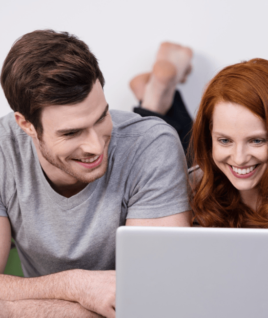 Happy couple with laptop | Tom's Carpet & Flooring Outlet